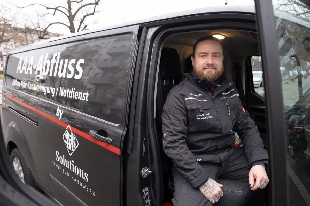 Techniker reinigt Kanal per Hochdruckspülung am Haus